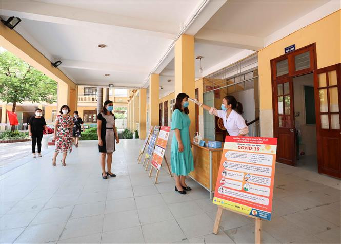 Việc đo thân nhiệt, sát khuẩn tay được các trường thực hiện thường xuyên, nghiêm túc. Ảnh: Thanh Tùng - TTXVN Năm học 2020 - 2021: Các trường học ở Hà Nội chủ động phòng, chống dịch COVID-19 ảnh 1