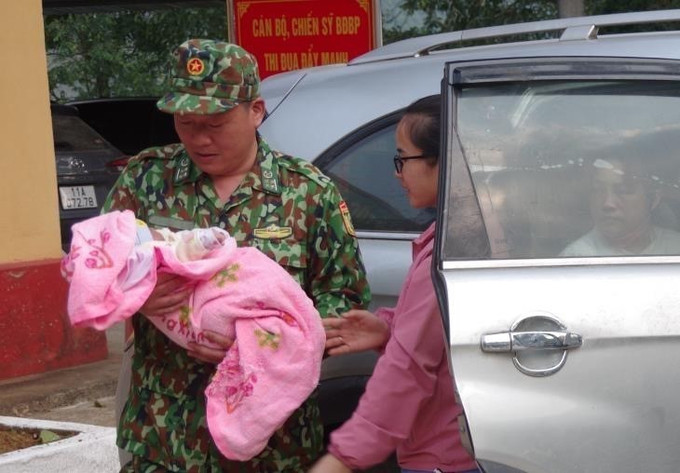 Đại diện Bộ đội Biên phòng Cao Bằng bàn giao cháu bé cho cơ quan bảo trợ xã hội địa phương. Ảnh: Nông Tuấn-TTXVN phát Cao Bằng: Phá chuyên án mua bán người dưới 16 tuổi ảnh 2