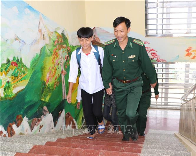 Các chiến sĩ biên phòng Đồn Thu Lũm dẫn các em học sinh đến trường học. Ảnh: Hoàng Thùy Oanh – TTXVN Tiếp bước em đến trường nơi vùng cao biên giới tỉnh Lai Châu (Bài 2) ảnh 1