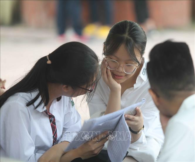 Thí sinh tranh thủ ôn lại kiến thức trước khi vào phòng thi. Ảnh: Thanh Tùng – TTXVN Kỳ thi vào lớp 10 THPT tại Hà Nội: Tạo điều kiện tốt nhất cho thí sinh, đảm bảo kỳ thi minh bạch, công bằng ảnh 2