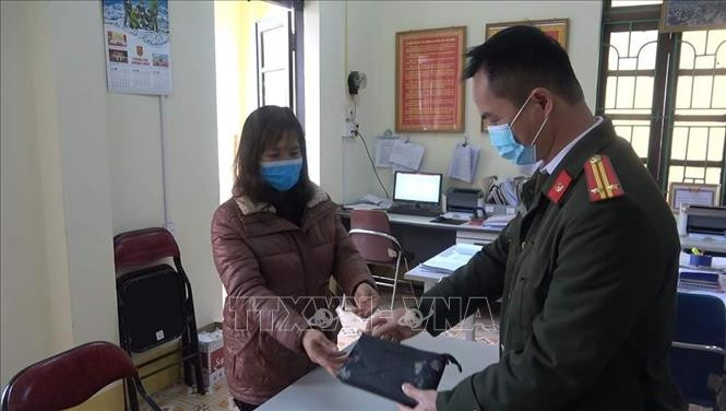 Chị Hoàng Hồng Lĩnh trao số tiền nhặt được cho Công an phường Tân Giang, (thành phố Cao Bằng, tỉnh Cao Bằng), đề nghị Công an phường tìm kiếm, xác minh, trao trả số tiền cho người mất. Ảnh: TTXVN Cao Bằng: Người phụ nữ trả lại hơn 100 triệu đồng cho người đánh rơi ảnh 1