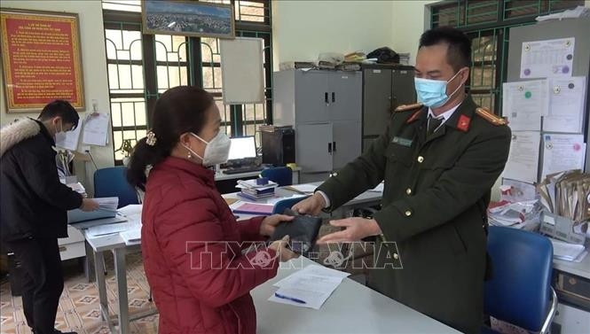 Công an phường Tân Giang, Thành phố Cao Bằng, tỉnh Cao Bằng trao trả tài sản bị đánh rơi cho bà Hoàng Thị Hương. Ảnh: TTXVN Cao Bằng: Người phụ nữ trả lại hơn 100 triệu đồng cho người đánh rơi ảnh 2