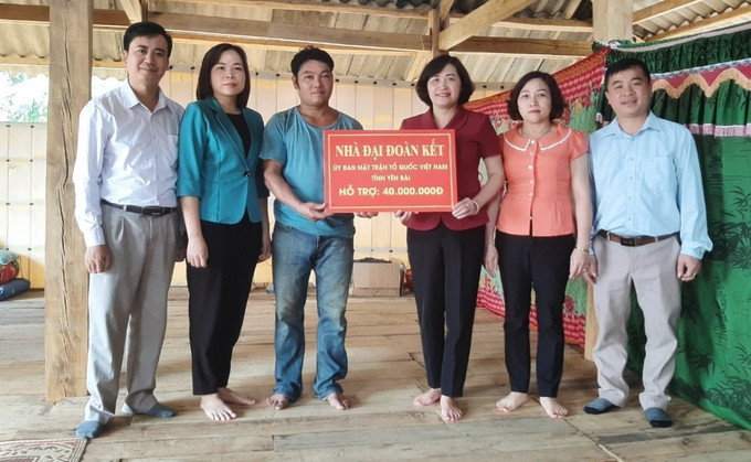 Lãnh đạo Ủy ban Mặt trận Tổ quốc tỉnh trao tiền hỗ trợ xây dựng “Nhà đại đoàn kết” cho hộ nghèo tại thị xã Nghĩa Lộ (Yên Bái). Ảnh: TTXVN phát Yên Bái: Chung tay xây dựng nhà ở cho người nghèo ảnh 3