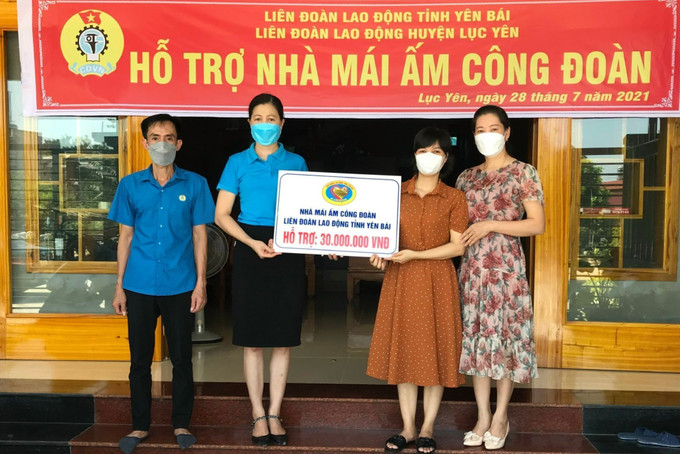 Lãnh đạo LĐLĐ huyện Lục Yên trao tiền hỗ trợ làm nhà “Mái ấm công đoàn” cho đoàn viên công đoàn Đỗ Thị Bích Diệp - Công đoàn cơ sở trường THCS Phúc Lợi, huyện Lục Yên. Ảnh: TTXVN phát Yên Bái: Chung tay xây dựng nhà ở cho người nghèo ảnh 2
