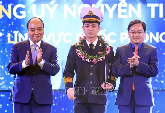 Chủ tịch nước Nguyễn Xuân Phúc và Bí thư thứ nhất TƯ Đoàn Nguyễn Anh Tuấn trao biểu trưng tuyên dương anh Nguyễn Tiến Duy, Gương mặt trẻ Việt Nam tiêu biểu năm 2021 trong lĩnh vực quốc phòng. Ảnh: Thống Nhất - TTXVN Chủ tịch nước Nguyễn Xuân Phúc dự Lễ trao Giải thưởng "Gương mặt trẻ Việt Nam tiêu biểu năm 2021" ảnh 2