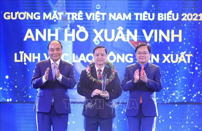 Chủ tịch nước Nguyễn Xuân Phúc và Bí thư thứ nhất TƯ Đoàn Nguyễn Anh Tuấn trao biểu trưng tuyên dương anh Hồ Xuân Vinh, Gương mặt trẻ Việt Nam tiêu biểu năm 2021 trong lĩnh vực lao động-sản xuất. Ảnh: Thống Nhất – TTXVN Chủ tịch nước Nguyễn Xuân Phúc dự Lễ trao Giải thưởng "Gương mặt trẻ Việt Nam tiêu biểu năm 2021" ảnh 5