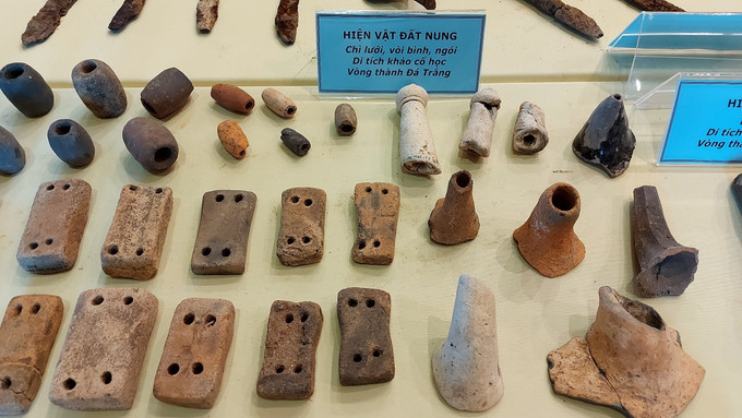 Trưng bày chì lưới, vật nhỏ làm bằng đất nung, buộc vào chài lưới đánh cá hoặc dây câu, được tìm thấy ở khu vực trung tâm của di tích Thành Đá Trắng, với số lượng khá lớn, tổng số lên đến hơn 120 hiện vật. Ảnh: Huỳnh Sơn-TTXVN Chùm ảnh về di tích thành cổ Vòng Thành Đá Trắng ảnh 3
