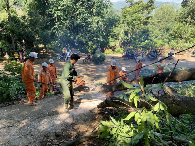 Cán bộ điện lực huyện Mường La và người dân phối hợp xử lý sự cố cây đổ vào đường dây điện 0,4kV. Ảnh: Hữu Quyết – TTXVN Sơn La chủ động phương án cấp điện trong mùa mưa lũ ảnh 2