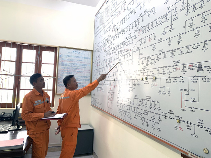 Cán bộ điện lực huyện Mường La kiểm tra sơ đồ hệ thống lưới điện trên địa bàn. Ảnh: Hữu Quyết – TTXVN Sơn La chủ động phương án cấp điện trong mùa mưa lũ ảnh 3