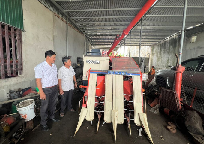 Ông Nguyễn Thanh Hùng (bên phải) giới thiệu về máy gặt đập liên hợp. Ảnh: Đinh Hương - TTXVN Lão nông Nguyễn Thanh Hùng tiên phong đưa cơ giới hóa vào sản xuất nông nghiệp ảnh 1