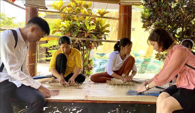 Du khách trải nghiệm làm sản phẩm từ mây tre. Ảnh: Mai Trang-TTXVN Thay đổi nhận thức bảo vệ thiên nhiên từ những sản phẩm bền vững ảnh 1