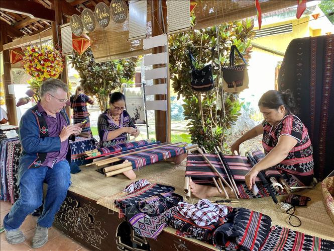 Du khách thích thú với hoạt động dệt thổ cẩm của người dân huyện Nam Đông. Ảnh: Mai Trang-TTXVN Thay đổi nhận thức bảo vệ thiên nhiên từ những sản phẩm bền vững ảnh 2