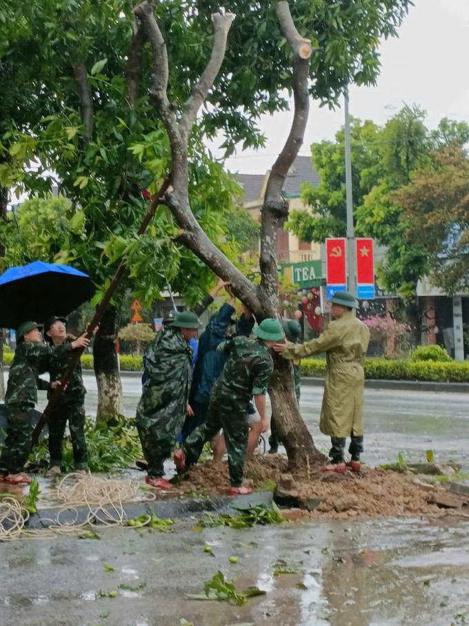 Bộ đội Biên phòng cùng các lực lượng dựng lại cây xanh gãy đổ trên đường. mua5.jpg