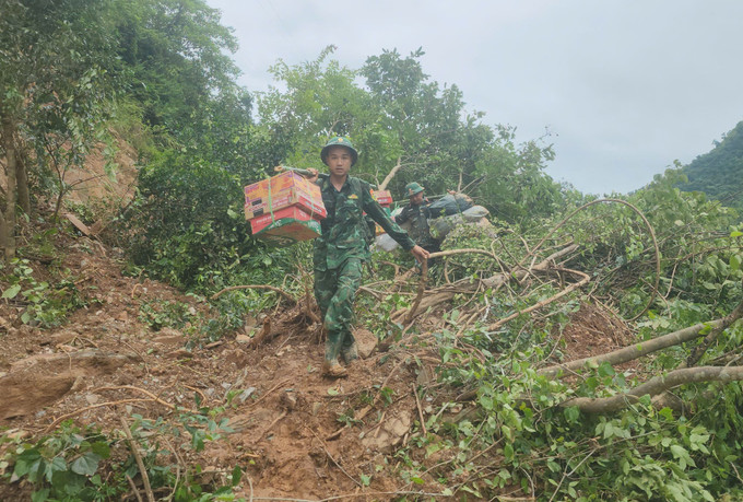 Đường vào vùng lũ Tây Nghệ An đang bị sạt lở, cô lập, nên Bộ đội Biên phòng phải gánh, vác những vật dụng thiết yếu cứu giúp nhân dân. anh8.jpg