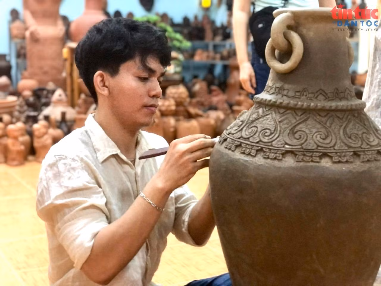 Nghệ nhân làng gốm Bàu Trúc đang chăm chút tỉa những chi tiết nghệ thuật đặc sắc trên bình gốm.