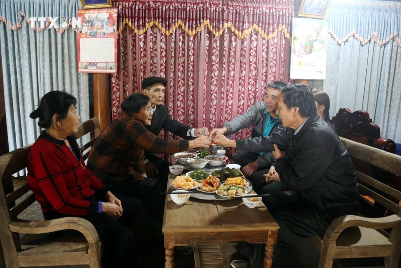 Một gia đình người Nguồn quây quần bên mâm cơm báo hiếu cha mẹ. Ảnh: TTXVN phát