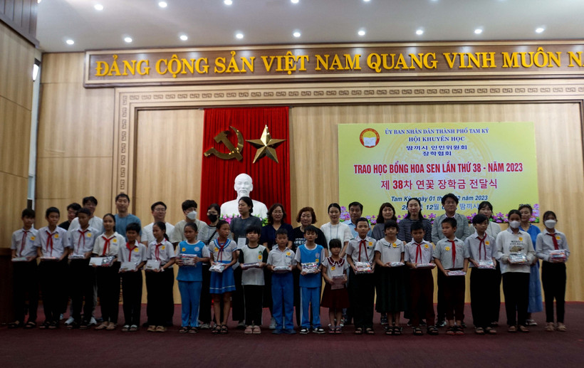 Các thành viên Làng Hoa Sen quốc tế Hàn Quốc trao học bổng cho học sinh. Ảnh: Trịnh Bang Nhiệm - TTXVN