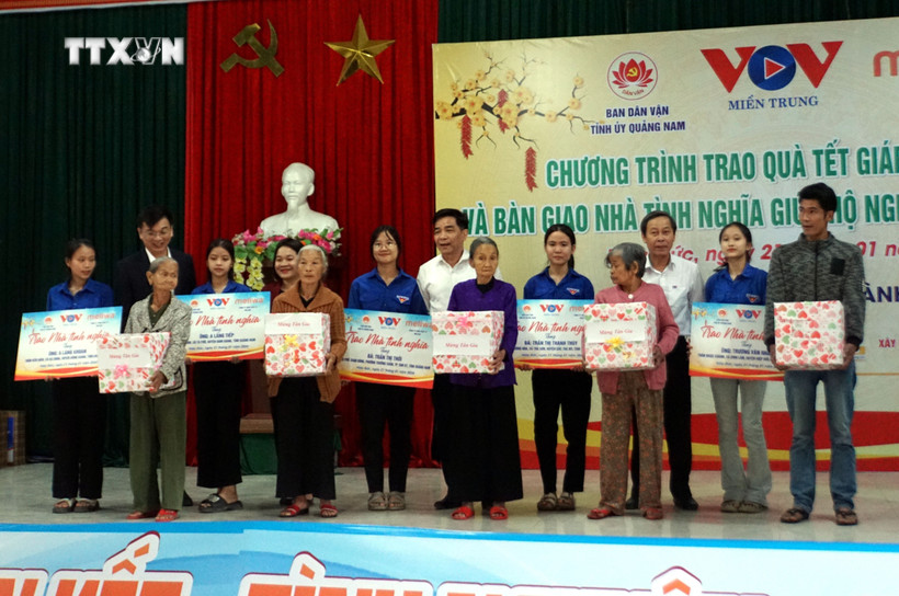 Ông Lê Văn Dũng, Phó Bí thư Thường trực Tỉnh ủy, Trưởng Đoàn đại biểu Quốc hội tỉnh Quảng Nam và đại diện Cơ quan thường trú Khu vực miền Trung - Đài Tiếng nói Việt Nam trao Nhà tình nghĩa cho các hộ gia đình. Ảnh: Trịnh Bang Nhiệm - TTXVN