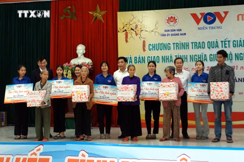 Ông Lê Văn Dũng, Phó Bí thư Thường trực Tỉnh ủy, Trưởng Đoàn đại biểu Quốc hội tỉnh Quảng Nam và đại diện Cơ quan thường trú Khu vực miền Trung - Đài Tiếng nói Việt Nam trao Nhà tình nghĩa cho các hộ gia đình. Ảnh: Trịnh Bang Nhiệm - TTXVN