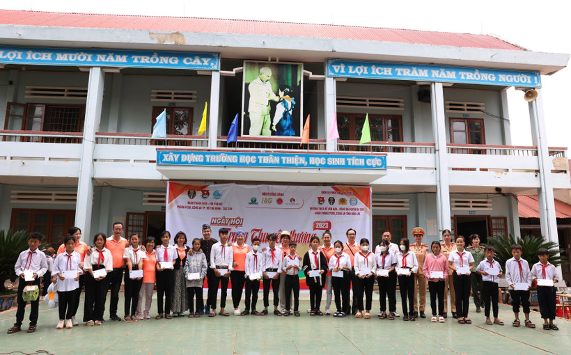 Ban tổ chức trao tặng học bổng cho học sinh có hoàn cảnh khó khăn vượt khó vươn lên trong học tập. Ảnh: Tuấn Anh – TTXVN