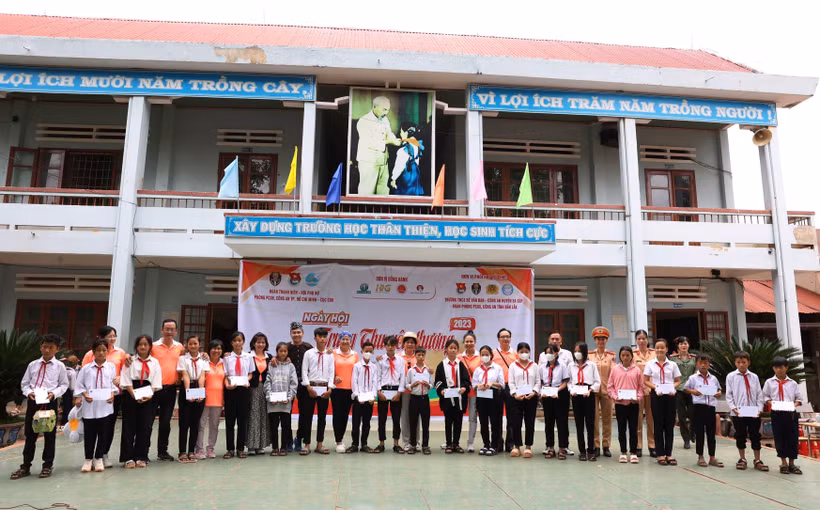 Ban tổ chức trao tặng học bổng cho học sinh có hoàn cảnh khó khăn vượt khó vươn lên trong học tập. Ảnh: Tuấn Anh – TTXVN