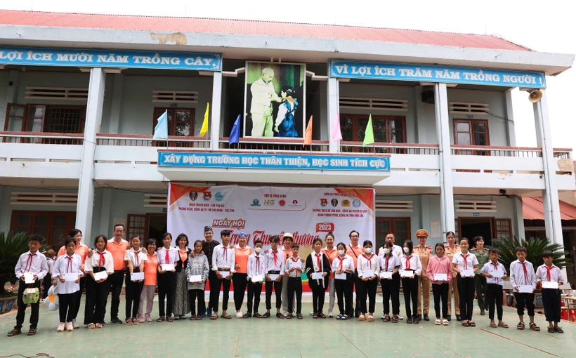 Ban tổ chức trao tặng học bổng cho học sinh có hoàn cảnh khó khăn vượt khó vươn lên trong học tập. Ảnh: Tuấn Anh – TTXVN