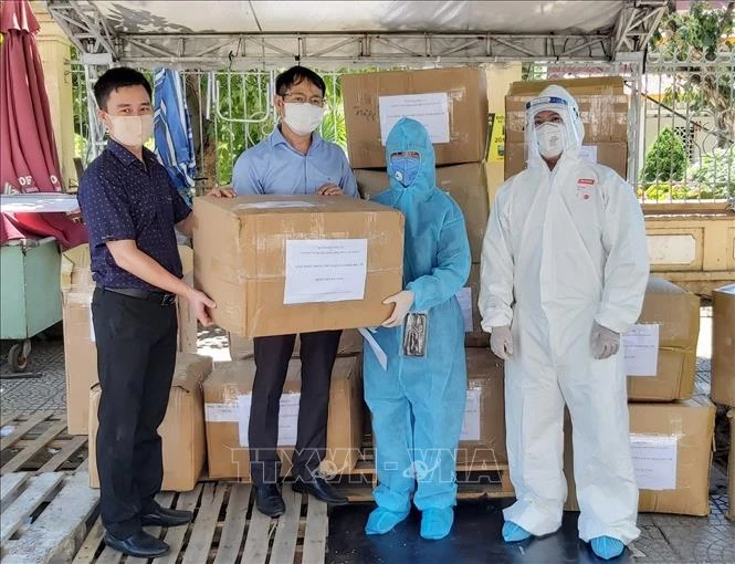 Đại diện Trung tâm Truyền hình Thông tấn và Cơ quan Thông tấn xã Việt Nam Khu vực miền Trung – Tây Nguyên tại Đà Nẵng trao tặng các thùng khẩu trang N95 và đồ bảo hộ y tế cho Bệnh viện C Đà Nẵng. Ảnh: TTXVN phát