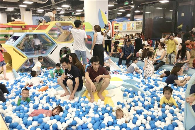 Nhiều phụ huynh và trẻ em không đeo khẩu trang tại khu vui chơi giải trí Vạn Hạnh Mall (Quận 10). Ảnh: Thanh Vũ - TTXVN