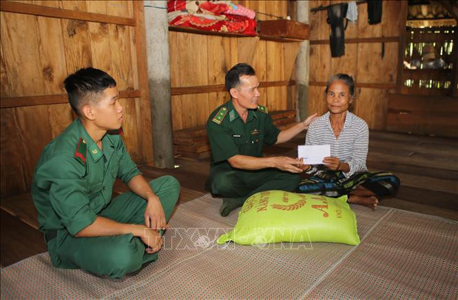 Bộ đội biên phòng Quảng Trị hỗ trợ gạo và tiền cho một hộ nghèo ở vùng biên giới huyện miền núi Hướng Hóa. Ảnh: Hồ Cầu - TTXVN 