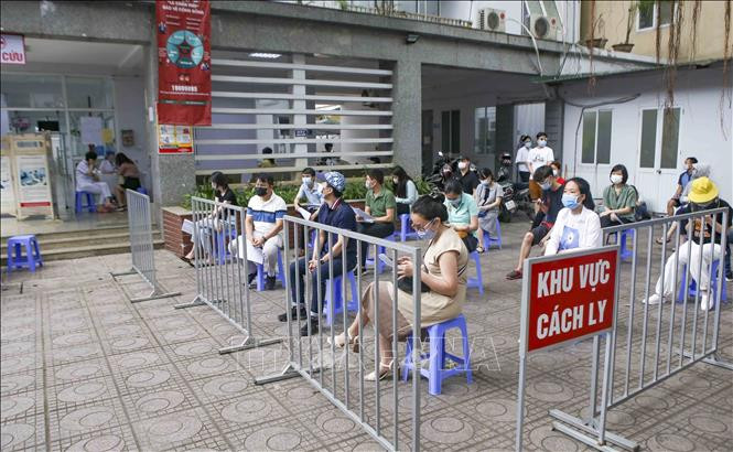 Những người làm việc tại tòa nhà T&T Group chờ lấy mẫu xét nghiệm. Ảnh: Tuấn Đức - TTXVN