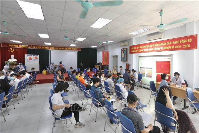 Người dân đến tiêm vaccine phòng COVID-19 tại điểm tiêm chủng quận Hai Bà Trưng (Hà Nội). Ảnh: Minh Quyết - TTXVN 