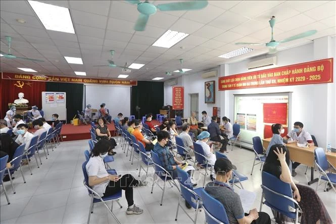 Người dân đến tiêm vaccine phòng COVID-19 tại điểm tiêm chủng quận Hai Bà Trưng (Hà Nội). Ảnh: Minh Quyết - TTXVN 