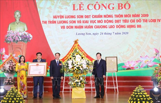 Đồng chí Trịnh Đình Dũng, Phó Thủ tướng Chính Phủ, Trưởng Ban Chỉ đạo Trung ương trao Bằng công nhận huyện Lương Sơn đạt chuẩn nông thôn mới và tặng hoa chúc mừng. Ảnh: Văn Điệp - TTXVN 