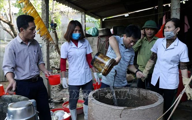Lực lượng y tế khử khuẩn giếng khơi cho người dân. Ảnh: Công Tường - TTXVN