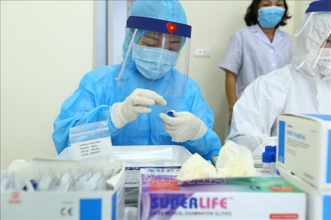 Nhân viên y tế lấy mẫu xét nghiệm nhanh cho người về từ Đà Nẵng, tại phường Bách Khoa và phường Cầu Dền (quận Hai Bà Trưng) sáng 01/8/2020. Ảnh: Minh Quyết - TTXVN