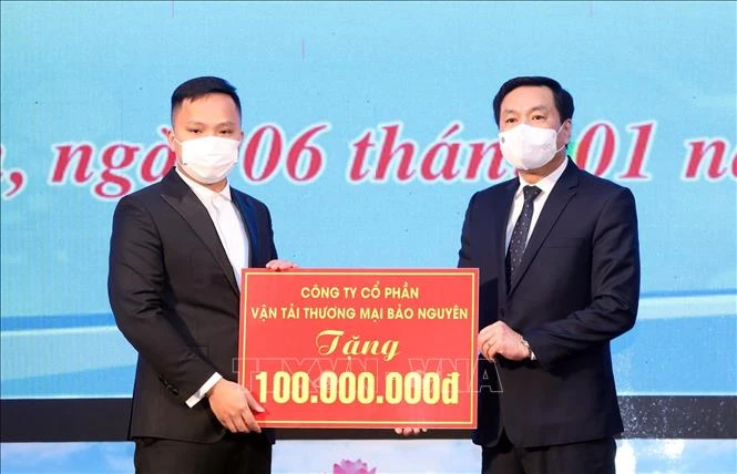 Chủ tịch UBND Thành phố Lạng Sơn Nguyễn Văn Hạnh (bên phải) nhận quà tặng từ các mạnh thường quân. Ảnh: Anh Tuấn – TTXVN 