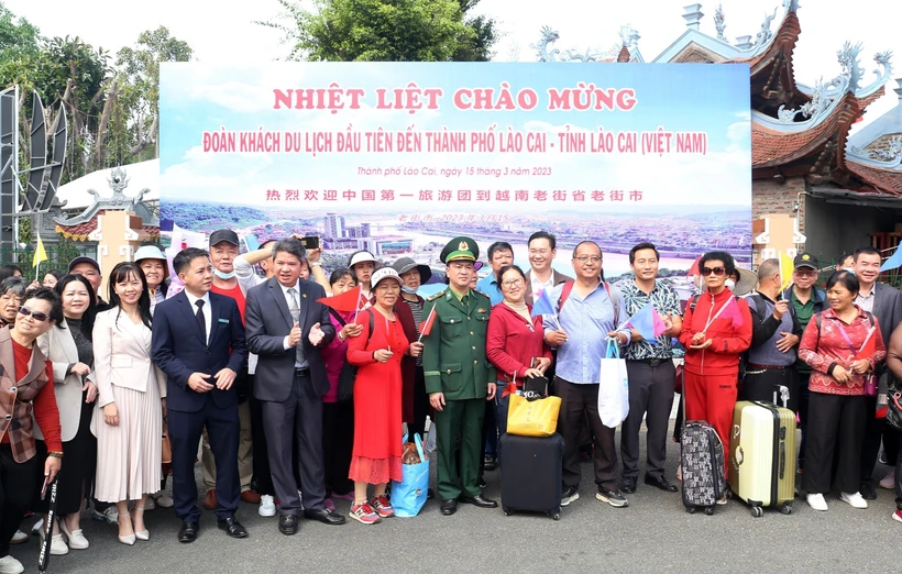 Đoàn khách du lịch đầu tiên chụp ảnh kỷ niệm tại cửa khẩu quốc tế Lào Cai. Ảnh: Quốc Khánh - TTXVN 