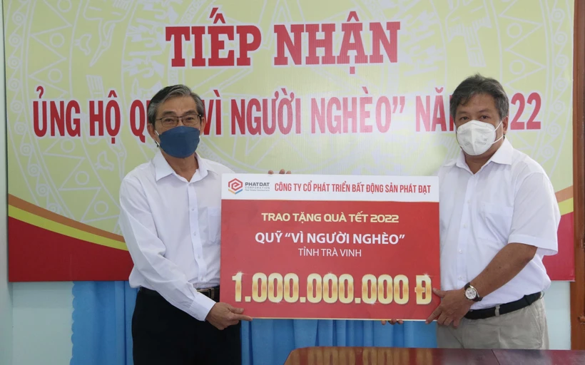 Chủ tịch Ủy ban Mặt trận Tổ quốc Việt Nam tỉnh Trà Vinh Nguyễn Văn Triết (bên trái) tiếp nhận 1 tỷ đồng hỗ trợ quà tết hộ nghèo từ Công ty Cổ phần Phát triển Bất động sản Phát Đạt. Ảnh: Thanh Hòa - TTXVN 