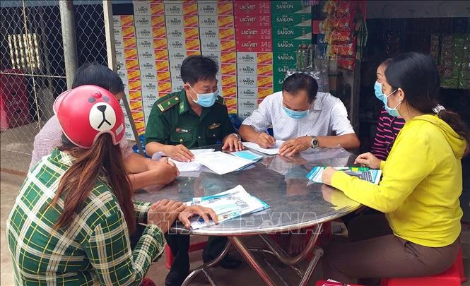 Bô đội Biên phòng tuyên truyền đến từng nhà dân cam kết thực hiện nghiêm khuyến cáo 5K của Bộ Y tế và không xuất nhập cảnh trái phép vực biên giới biển Sóc Trăng. Ảnh: Trung Hiếu - TTXVN