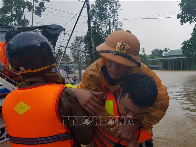 Di chuyển người dân ra khỏi khu vực ngập lũ tại huyện Cam Lộ. Ảnh: Thanh Thủy-TTXVN