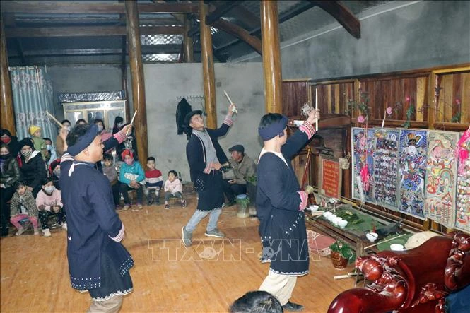 Thầy cúng và chủ nhà làm lễ trước ban thờ tổ tiên. Ảnh: Hữu Quyết - TTXVN 