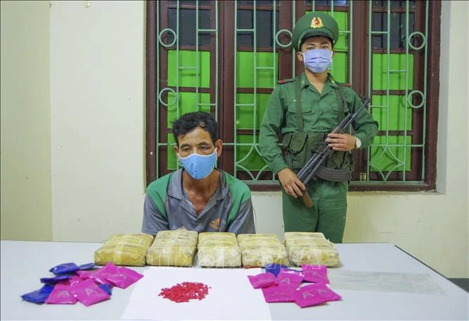 Đối tượng Lò Văn Yêu và tang vật bị thu giữ tại cơ quan điều tra. Ảnh: Xuân Tư - TTXVN
