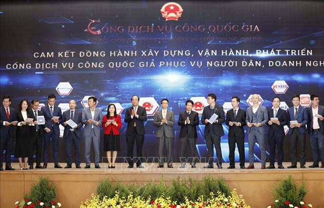 Phó Thủ tướng Vũ Đức Đam và Bộ trưởng, Chủ nhiệm Văn phòng Chính phủ Mai Tiến Dũng chứng kiến đại diện các ngân hàng ký điện tử, cam kết trung gian thanh toán trên Cổng Dịch vụ công Quốc gia. Ảnh: Dương Giang 
