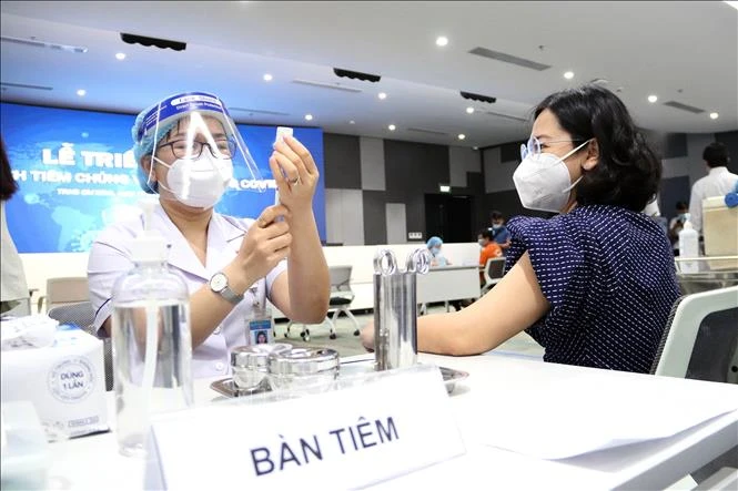 Các y, bác sỹ chuẩn bị thuốc tiêm chủng vaccine phòng COVID-19 cho người lao động. Ảnh: Thanh Vũ - TTXVN