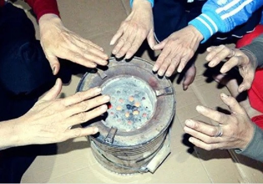 Người dân quây quần bên bếp lửa để sưởi ấm. Ảnh: Quang Quyết - TTXVN 