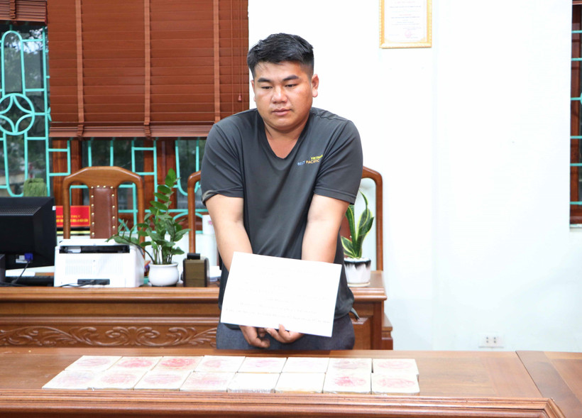 Đối tượng Cứ A Anh, sinh năm 1995, cư trú tại bản Tìa Ló B, xã Nong U, huyện Điện Biên Đông, tỉnh Điện Biên và tang vật 16 bánh heroin. Ảnh: Nguyễn Oanh-TTXVN 