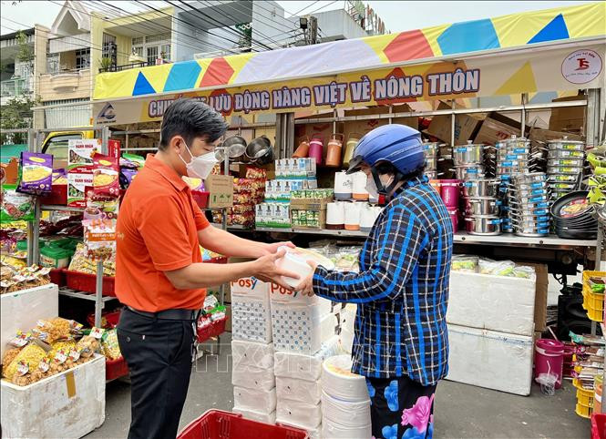 Người dân mua sắm tại chuyến xe lưu động đưa hàng Việt về nông thôn tại huyện Châu Thành, An Giang. Ảnh: Thanh Sang – TTXVN 