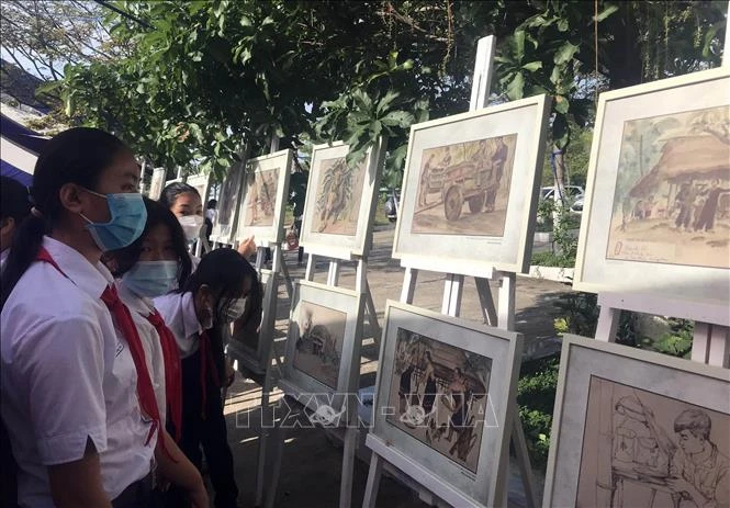 Học sinh xem triển lãm tranh lưu động “Ký họa chiến trường Khu V” sau lễ khai mạc. Ảnh: TTXVN phát 