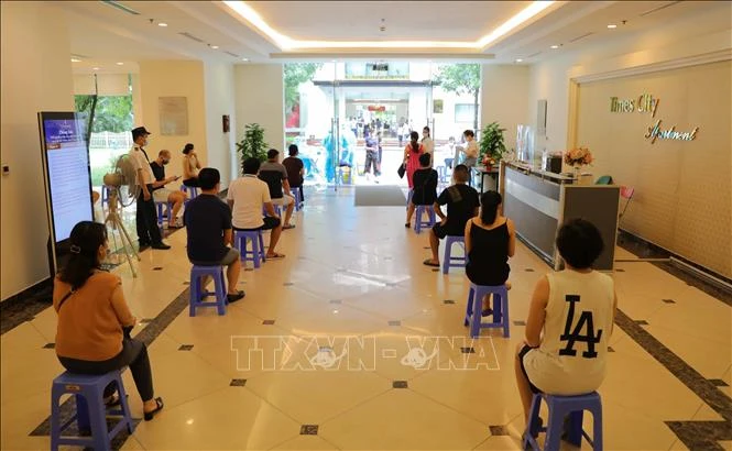 Cư dân ngồi giãn cách đợi lấy mẫu xét nghiệm SARS-CoV-2 trong sáng 11/8. Ảnh: Thanh Tùng - TTXVN 