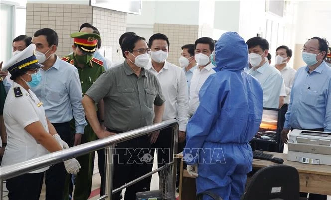 Thủ tướng Phạm Minh Chính thăm hỏi, động viên các đơn vị làm nhiệm vụ tại Trạm liên hợp cửa khẩu quốc tế Mộc Bài. Ảnh: Lê Đức Hoảnh - TTXVN 